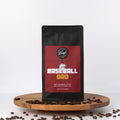 Coffee bag labeled 'Baseball Dad' on a wooden platform with scattered coffee beans.