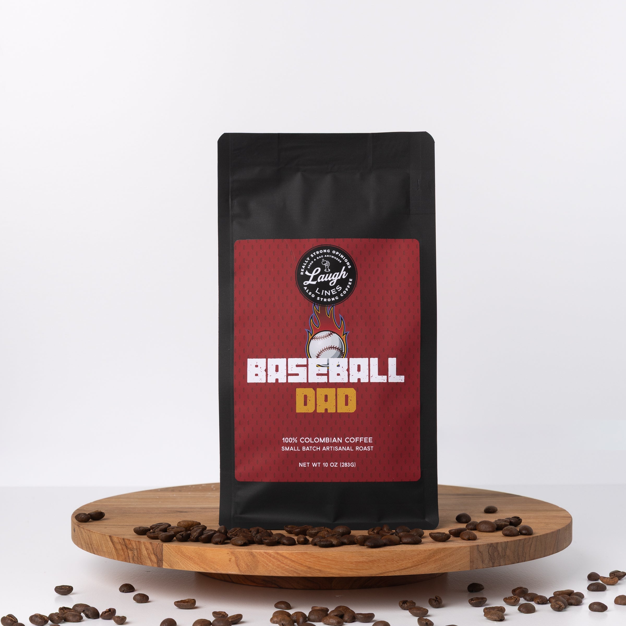 Coffee bag labeled 'Baseball Dad' on a wooden platform with scattered coffee beans.