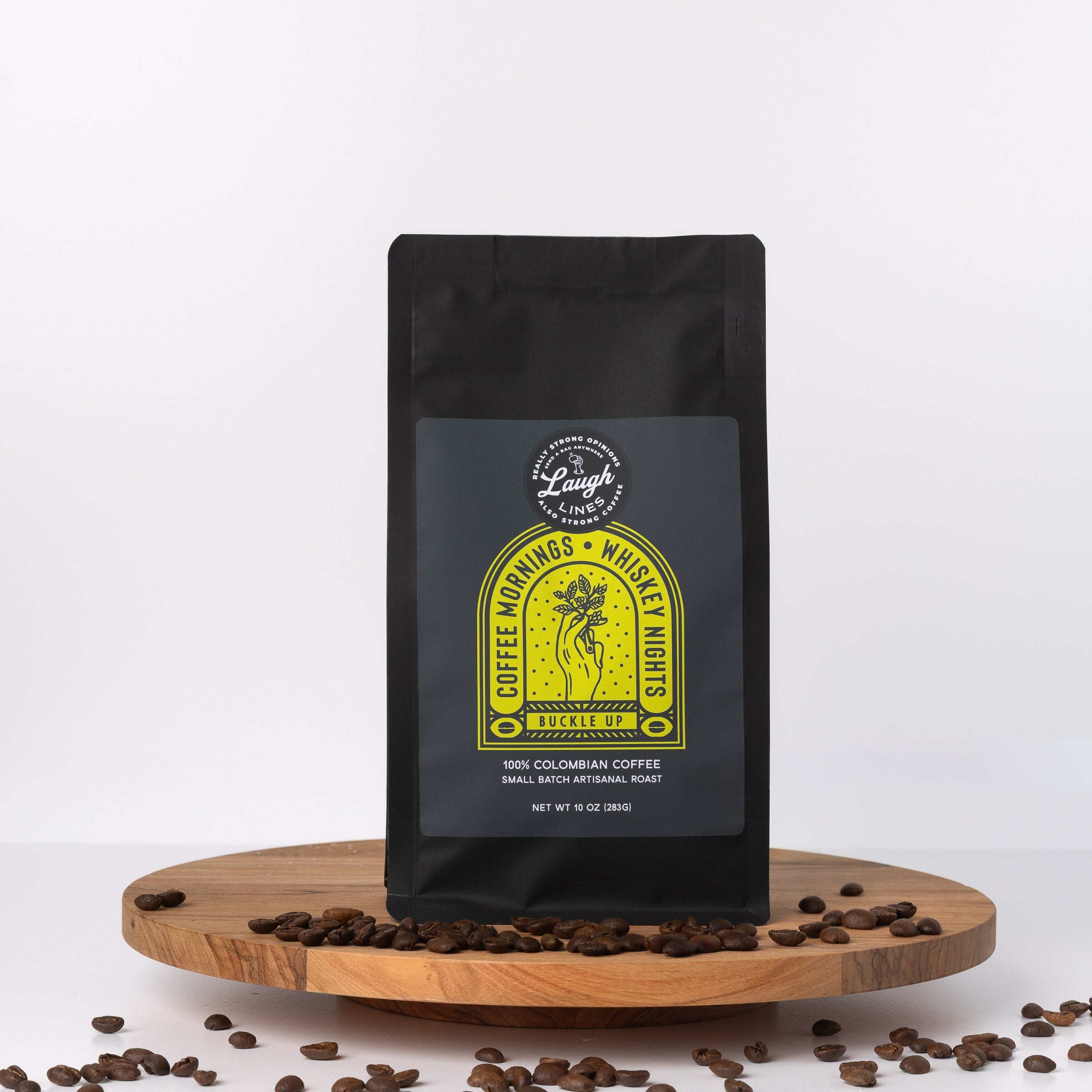 Black coffee bag with yellow label that says 'Coffee Mornings. Whiskey Nights. Buckle Up.' on a white background