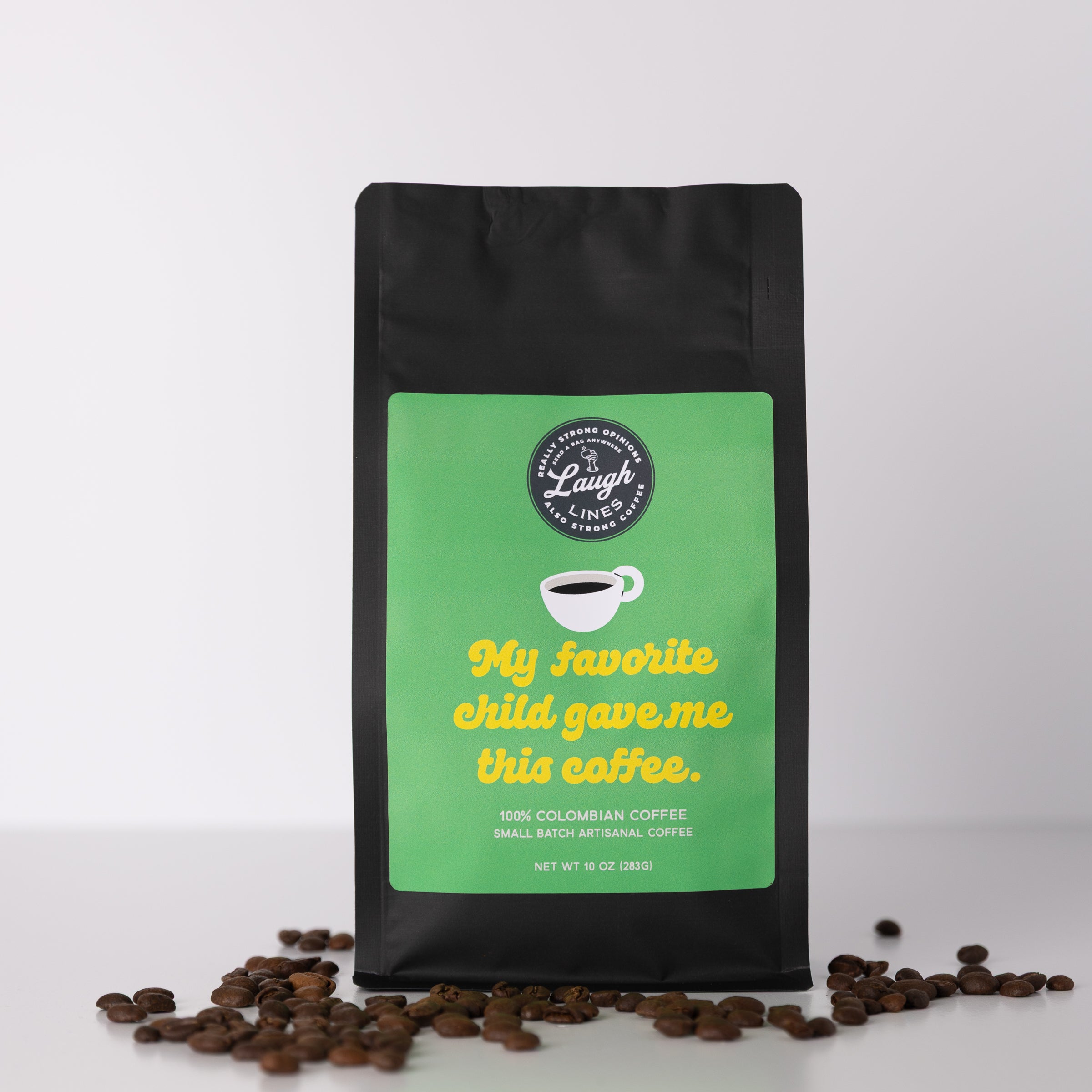 Coffee bag with green label that reads 'My Favorite Child Gave Me This Coffee' and coffee beans on a white background
