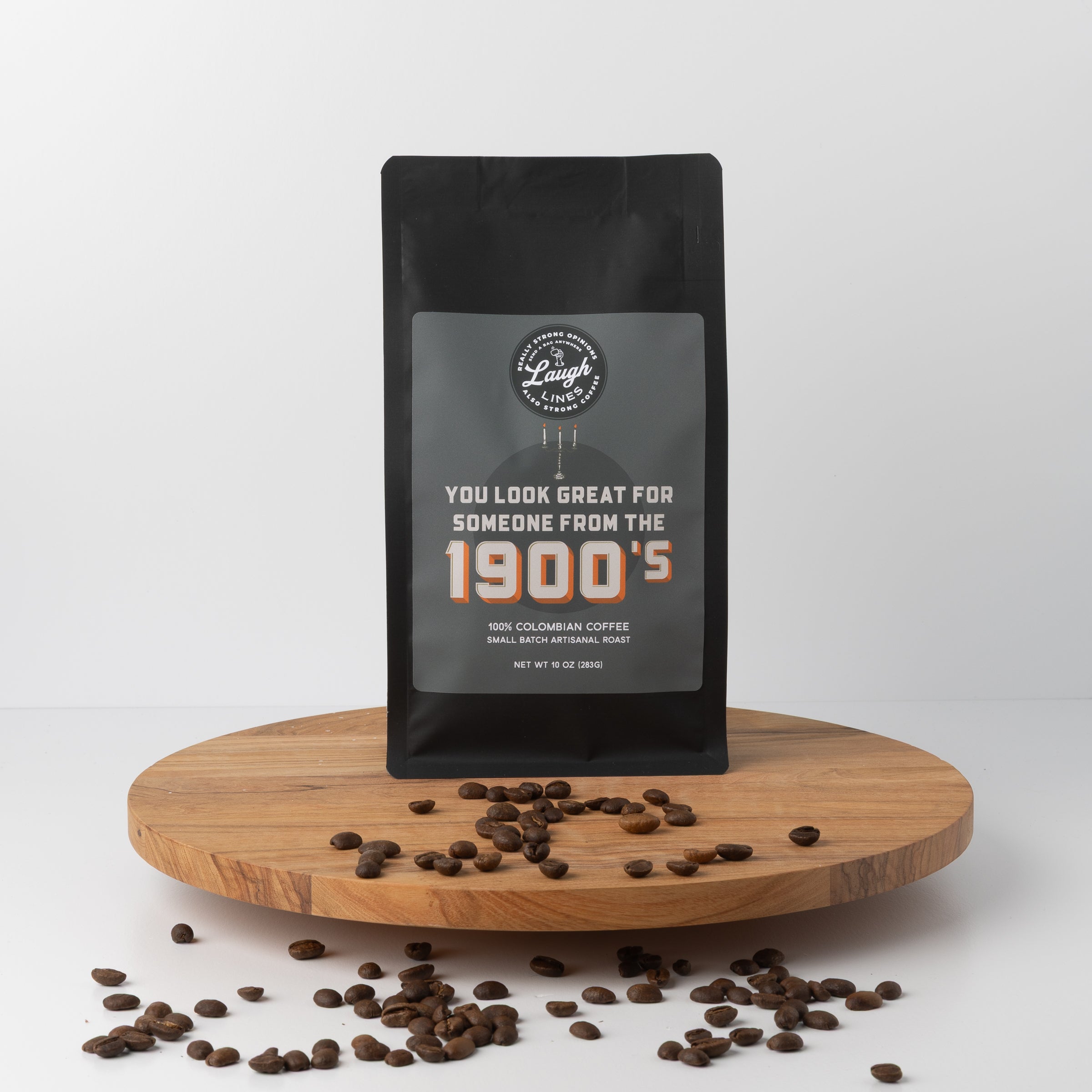 Coffee bag with text that reads, "You Look Great for Someone from the 1900's" on a wooden platform with scattered coffee beans