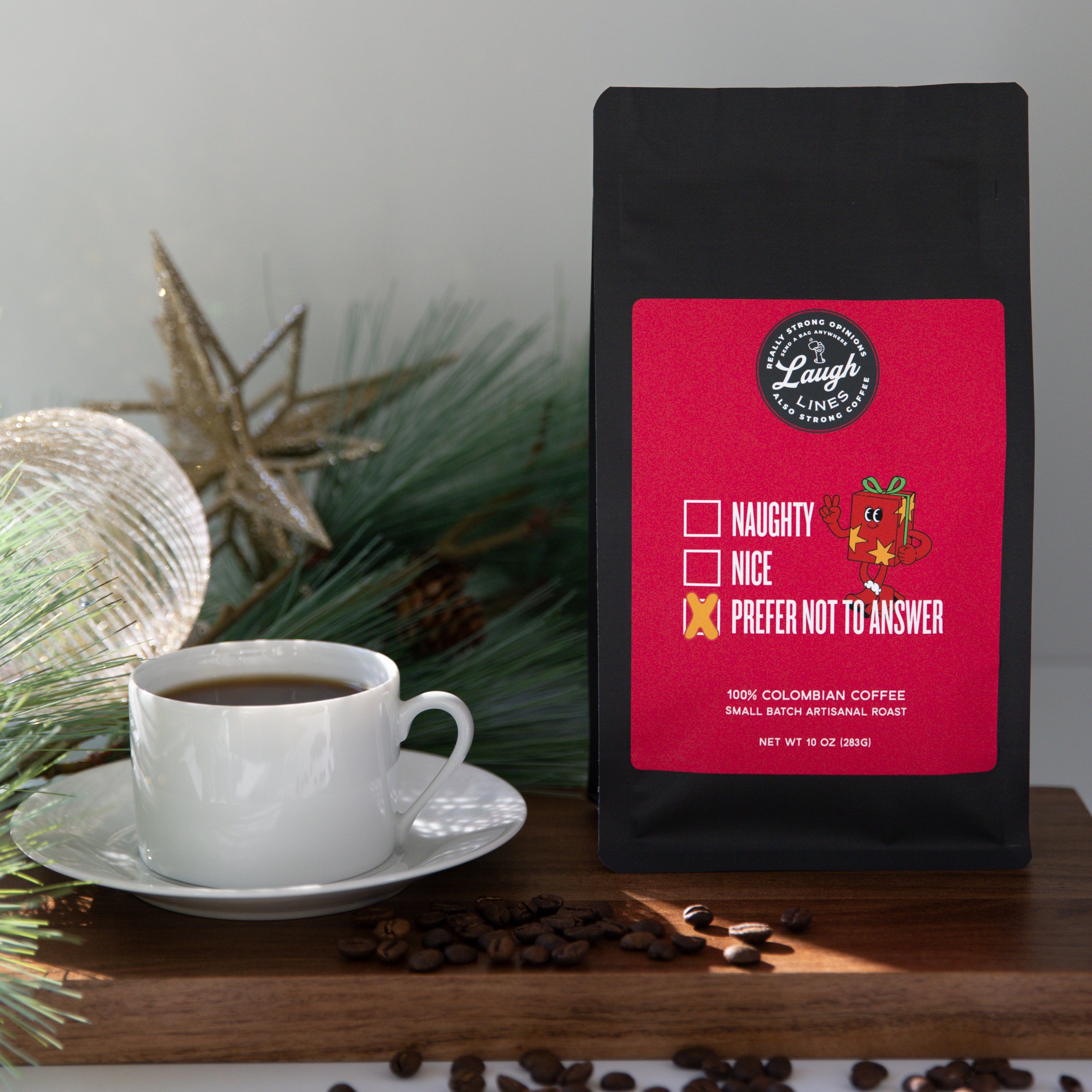 Coffee bag with a humorous text label that says Naughty, Nice, Prefer Not to Answer next to a cup of coffee on a wooden surface.