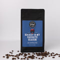 Coffee bag with 'Hockey is my Favorite Season' text and coffee beans on a white background