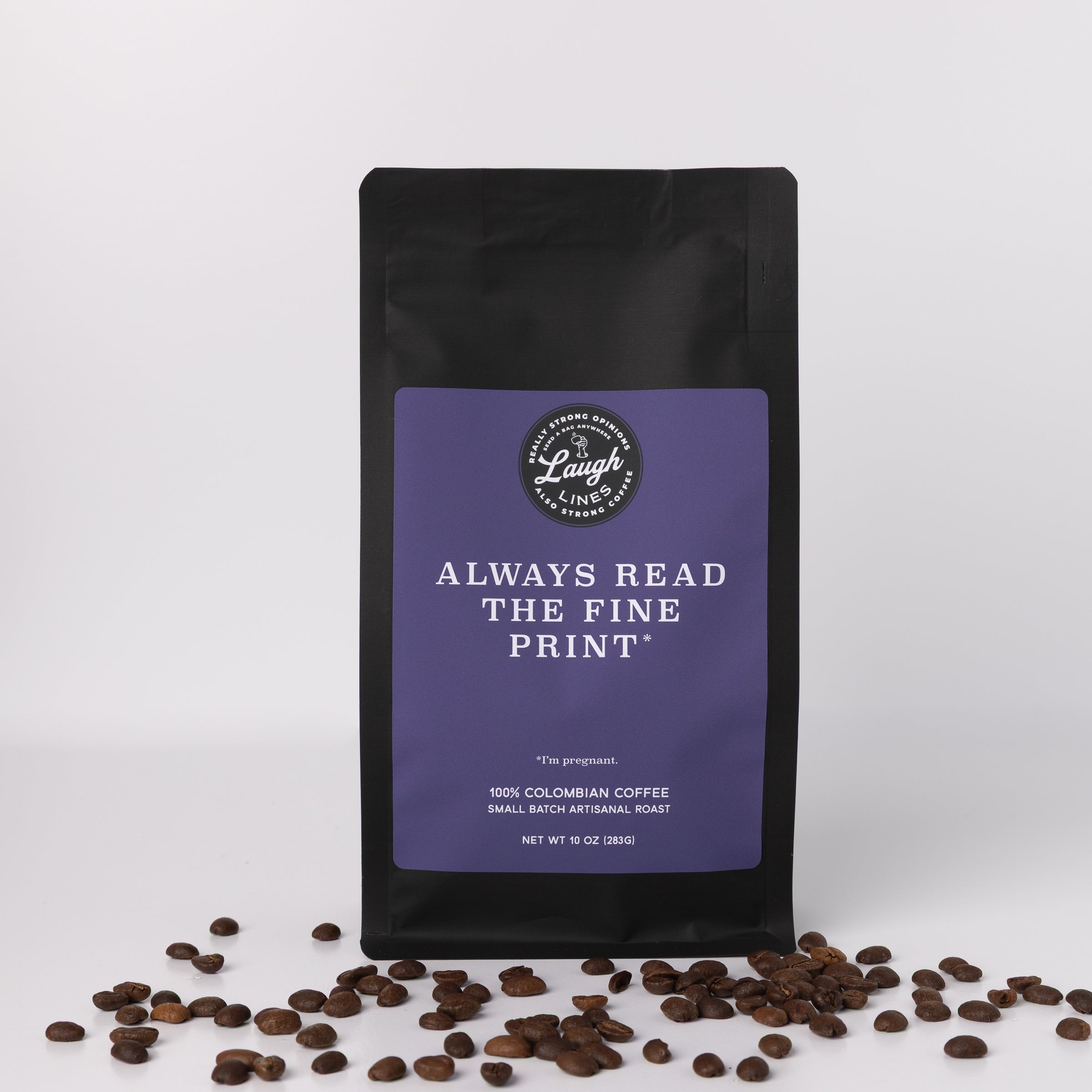Coffee bag with purple label that says 'Always Read the Fine Print. I'm Pregnant' and coffee beans on a white background