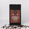 Coffee bag with 'Lacrosse is My Favorite Season' text and coffee beans on a white background